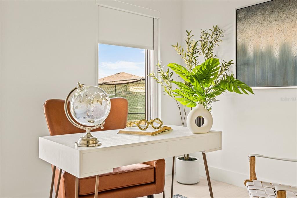 A home office features a white desk, a leather chair, a globe, and a plant — 6450 OCTAVE STREET DRIVE, MASCOTTE, FL