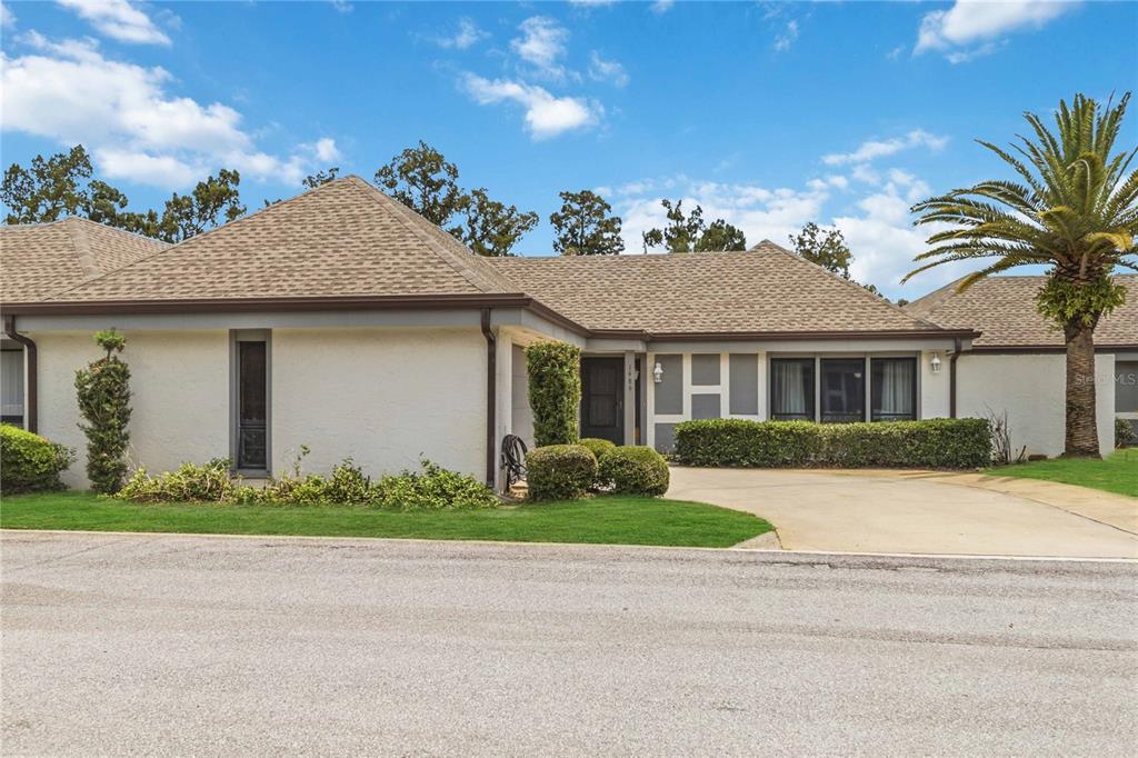 A single-story house with a beige stucco exterior, a brown shingled roof, and a palm tree — 1489 MAGELLAN CIRCLE UNIT 603, ORLANDO, FL