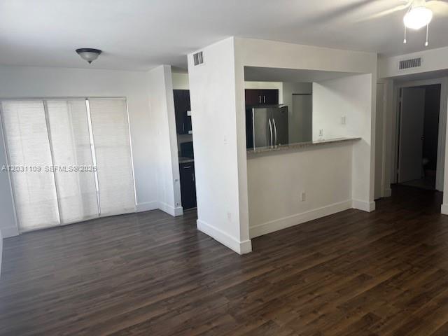 An interior view shows a living area with wood-look flooring and a kitchen pass-through window — 15275 SW 107th Ln # 102, Miami FL 33196, MIAMI, FL