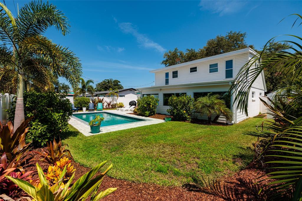 A two-story white house with a backyard swimming pool and lush tropical landscaping — 5950 35TH AVENUE N, ST PETERSBURG, FL