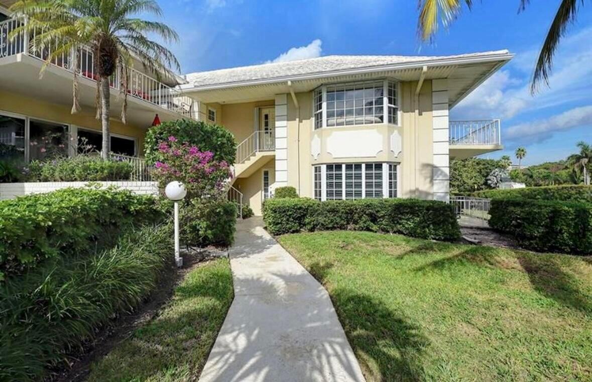 A two-story beige building with a concrete walkway, bay windows, and surrounding landscaping — 1299 S Ocean Boulevard # L5, Boca Raton FL 33432, BOCA RATON, FL