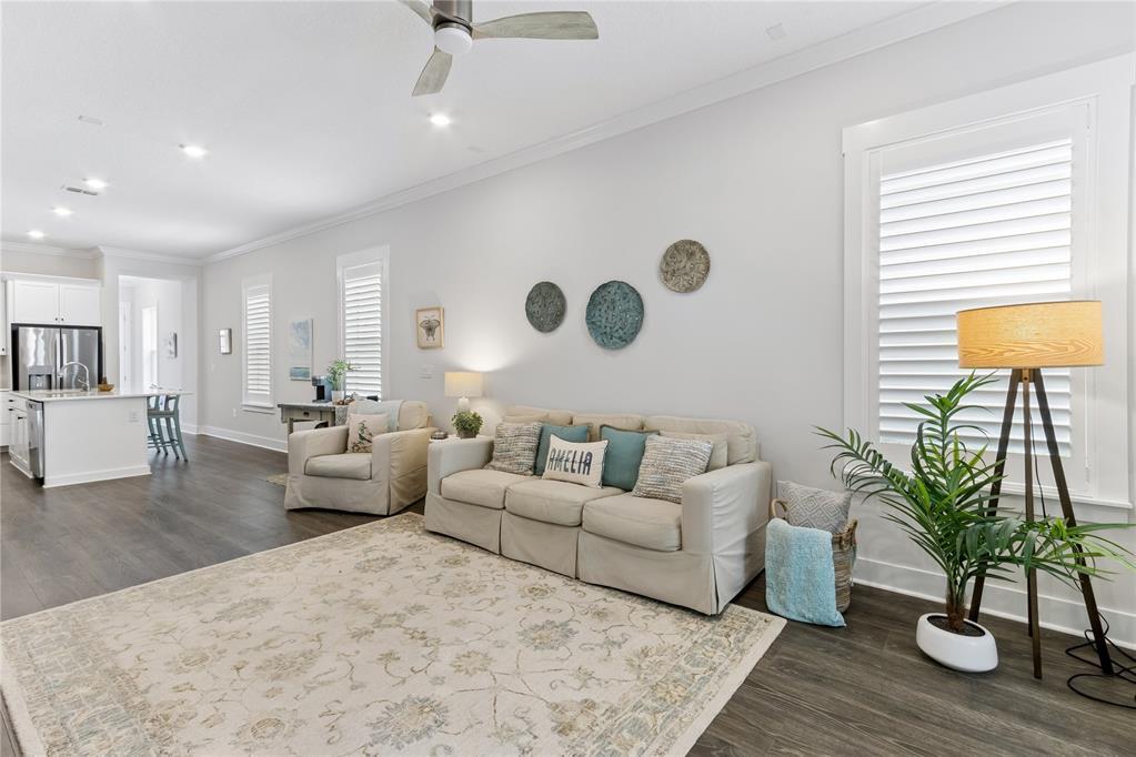 A living room features a beige sofa, an armchair, a patterned rug, and a floor lamp — 95984 Mimosa Drive, FL 32034, FL