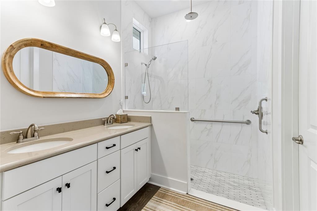 A bathroom features a double vanity with a wooden mirror and a walk-in tiled shower — 95984 Mimosa Drive, FL 32034, FL