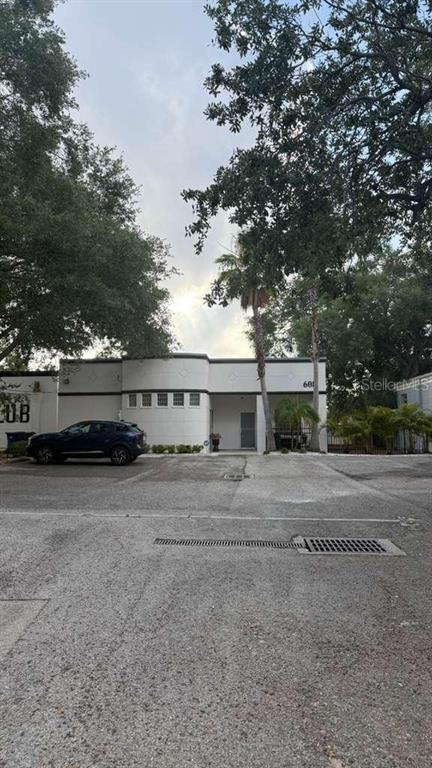 A single-story commercial building with a white facade and a dark blue car parked outside — 608 S TAMPANIA AVENUE, TAMPA, FL