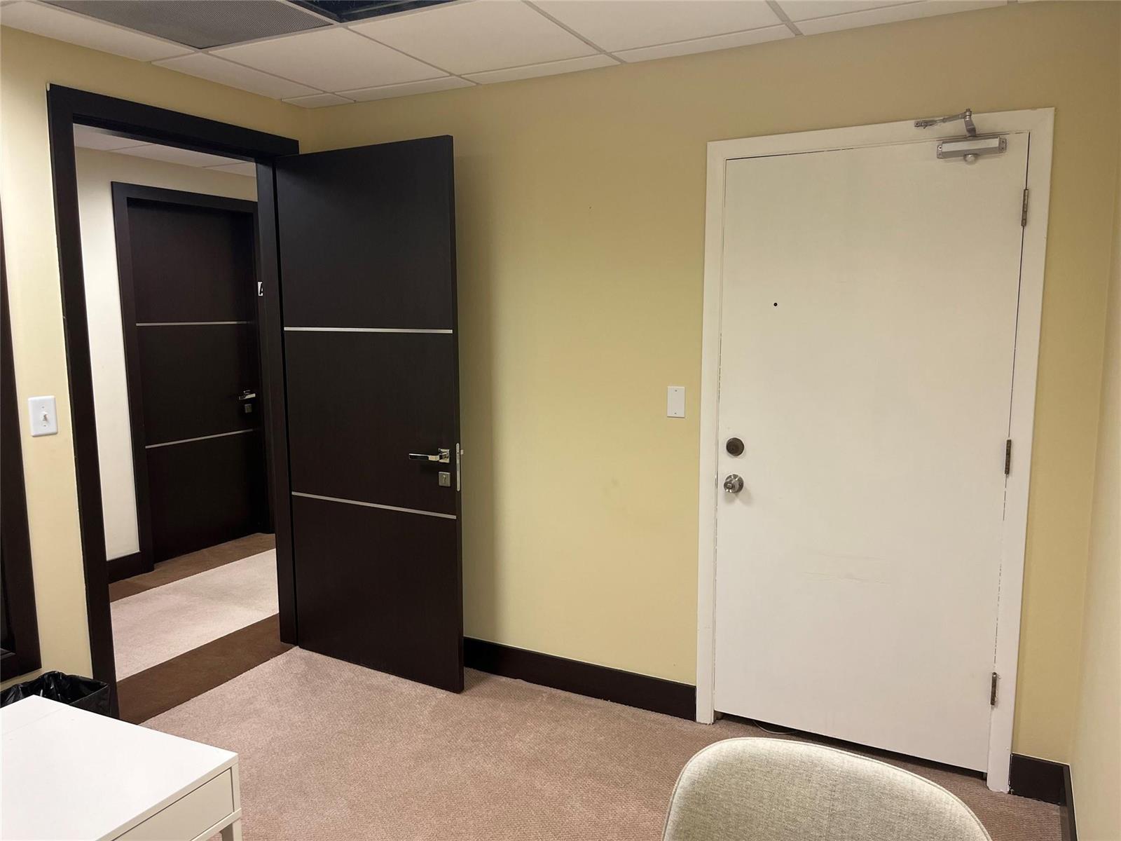 An office interior features a dark wooden door, a white door, and beige carpet — 2730 SW 3rd Avenue # 202C, Miami FL 33129, MIAMI, FL