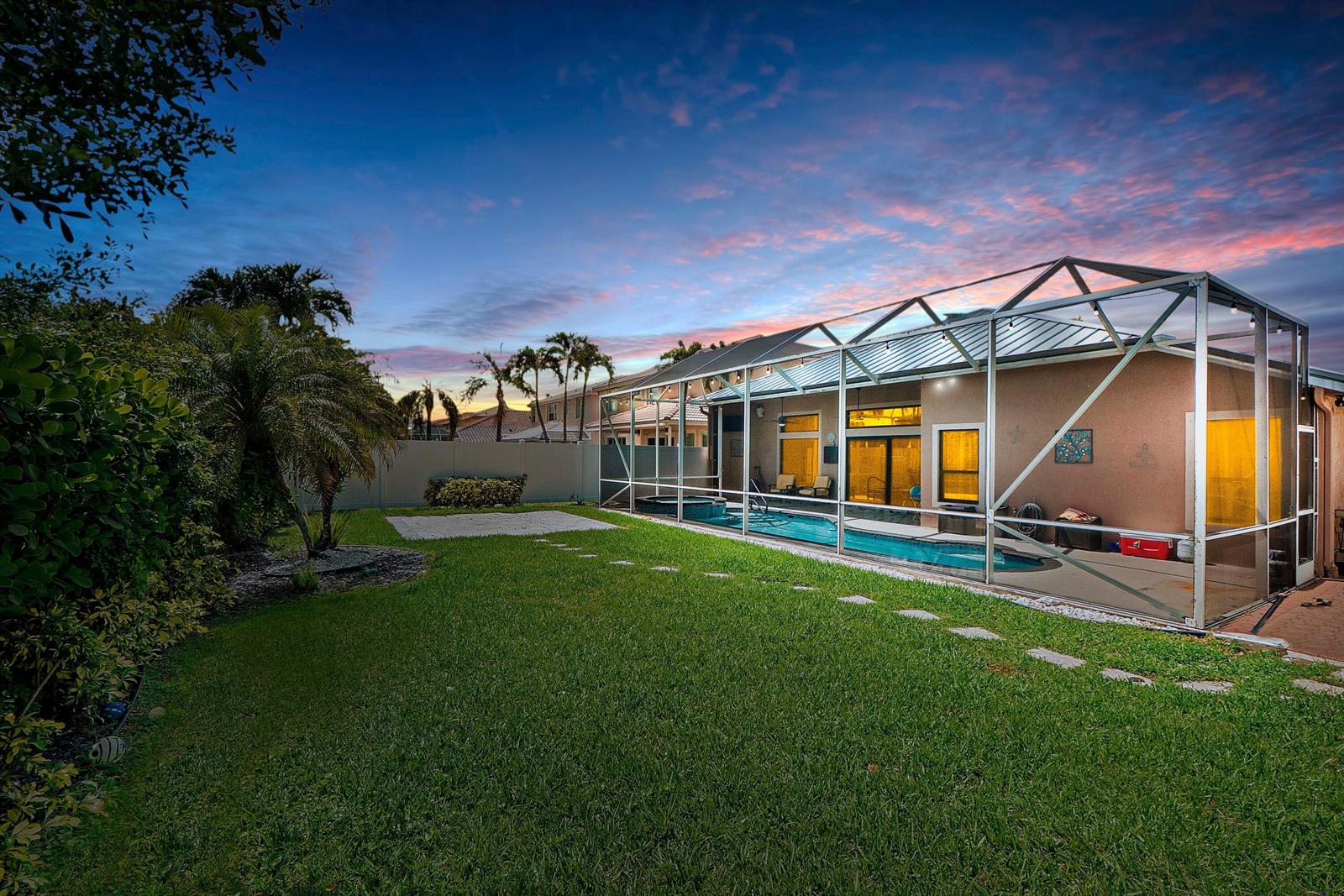 A backyard with a swimming pool enclosed by a screen cage and a grassy lawn — 12328 Saint Simon Drive, Boca Raton FL 33428, BOCA RATON, FL