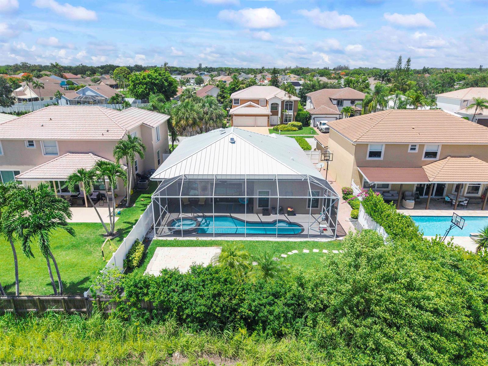 An aerial view of a suburban house with a screened-in pool and backyard — 12328 Saint Simon Drive, Boca Raton FL 33428, BOCA RATON, FL