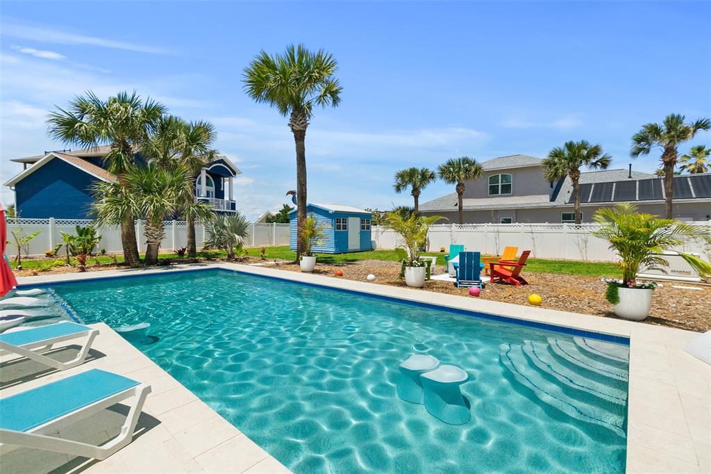 A backyard swimming pool with lounge chairs, palm trees, and a small blue shed — 1807 N CENTRAL AVENUE, FLAGLER BEACH, FL