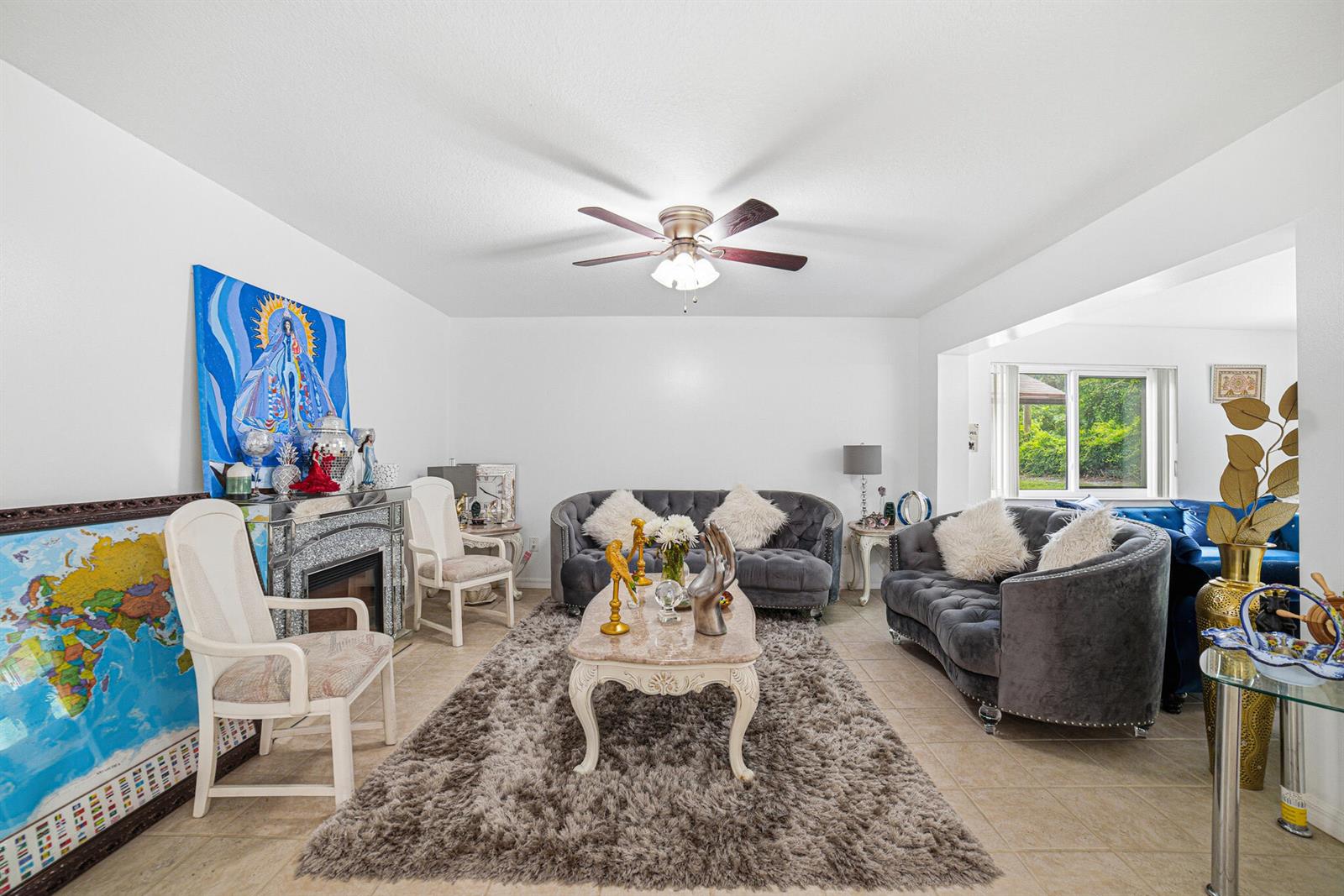 A living room features two grey tufted sofas, a coffee table, and a fireplace — 6335 Tall Cypress Circle, FL 33463, FL