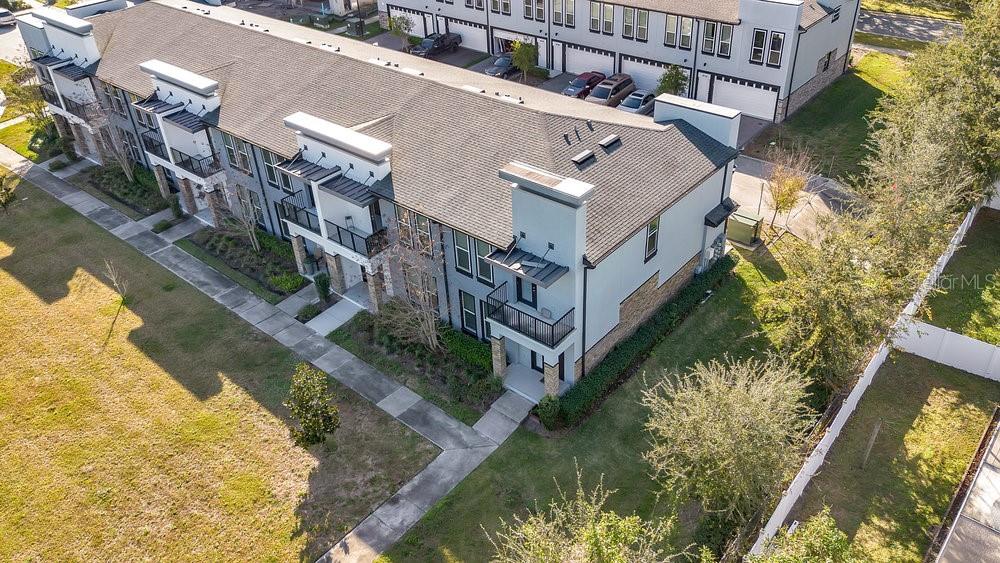 An aerial view shows a multi-story townhome complex with balconies and attached garages — 1861 HOUSTON STREET, KISSIMMEE, FL