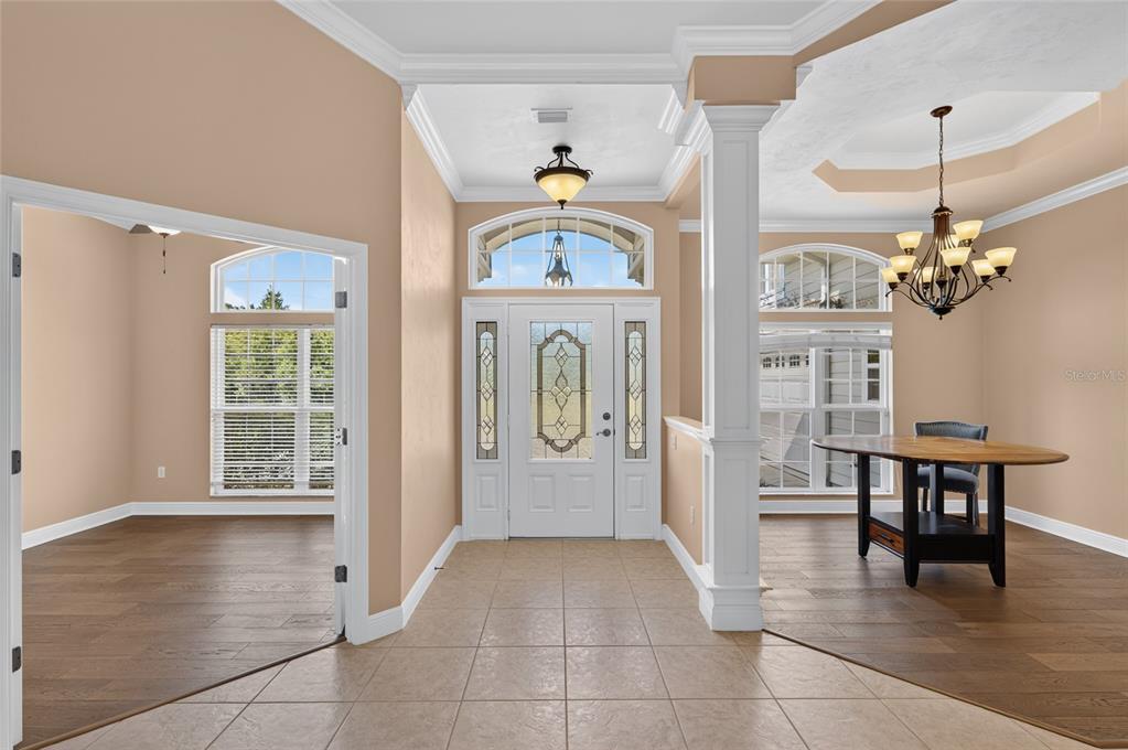An entryway with tile flooring, a glass-paneled front door, and an adjacent dining area — 26807 SW 20TH PLACE, NEWBERRY, FL