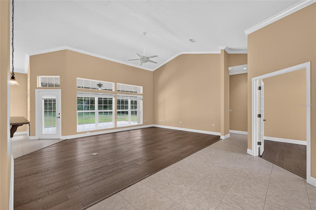 An open-concept living area features vaulted ceilings, dark wood flooring, and light-colored tile — 26807 SW 20TH PLACE, NEWBERRY, FL