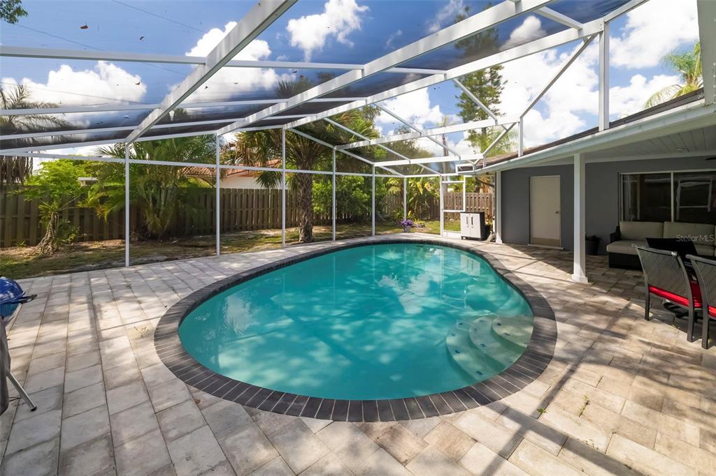 A backyard swimming pool with a screen enclosure and a paved patio area — 3304 SPRING MILL CIRCLE, SARASOTA, FL