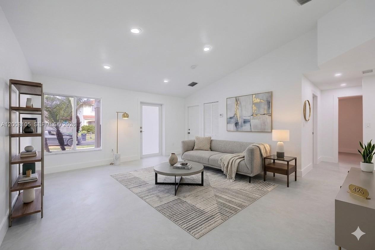 A bright living room features white walls, light tile flooring, a gray sofa, and shelving — 21505 SW 89th Path, Cutler Bay FL 33189, CUTLER BAY, FL