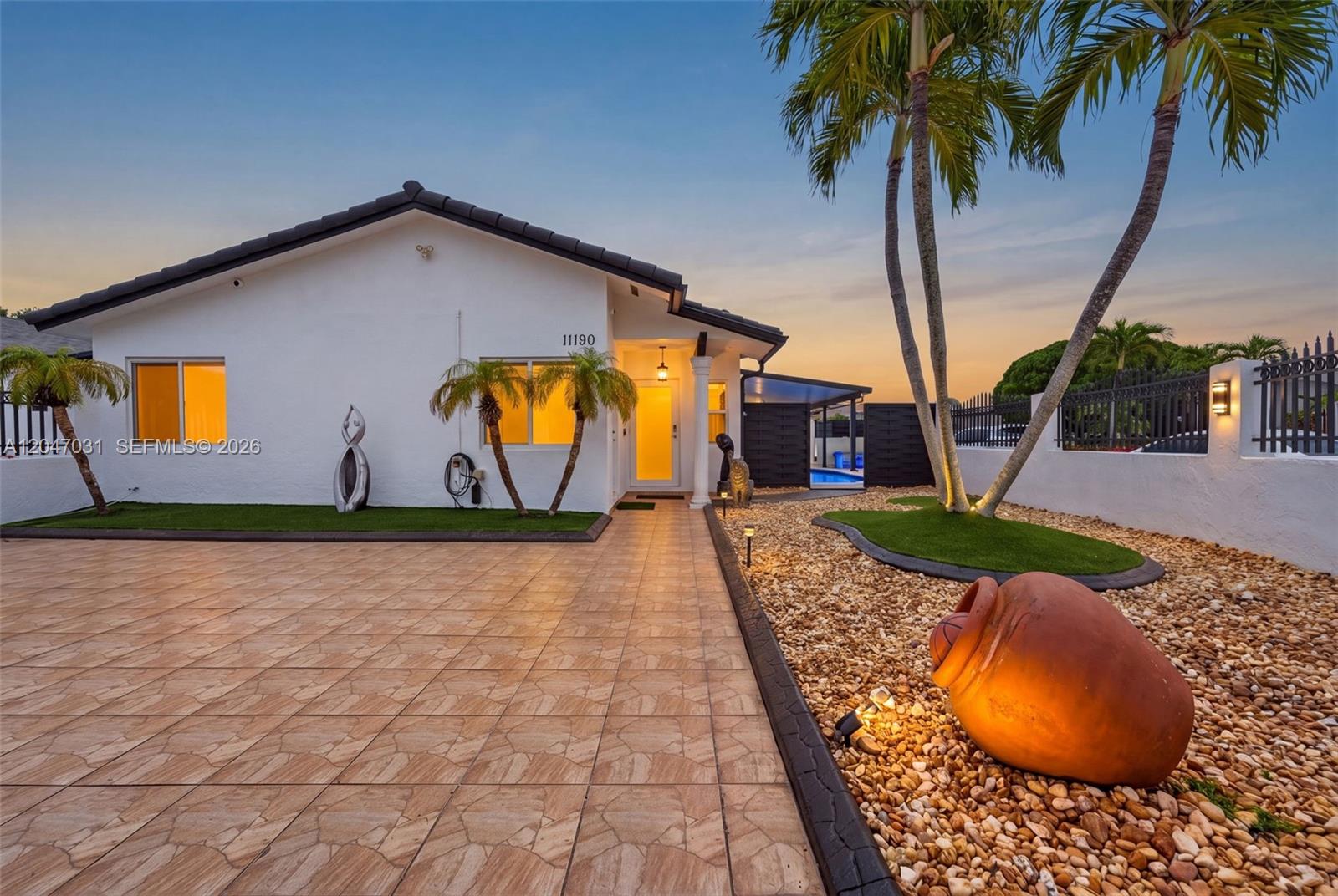 A white house exterior features a tiled driveway, gravel landscaping, palm trees, and a pool — 1635 SW 138th Ct, Miami FL 33175, MIAMI, FL