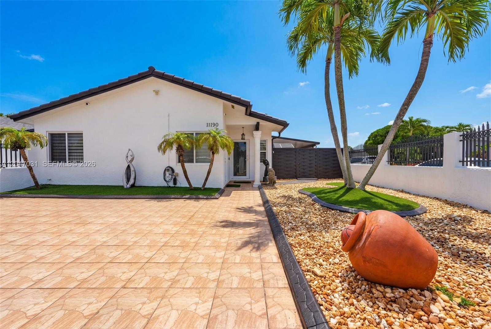 A white house features a tiled driveway, palm trees, and a large decorative clay pot — 1635 SW 138th Ct, Miami FL 33175, MIAMI, FL