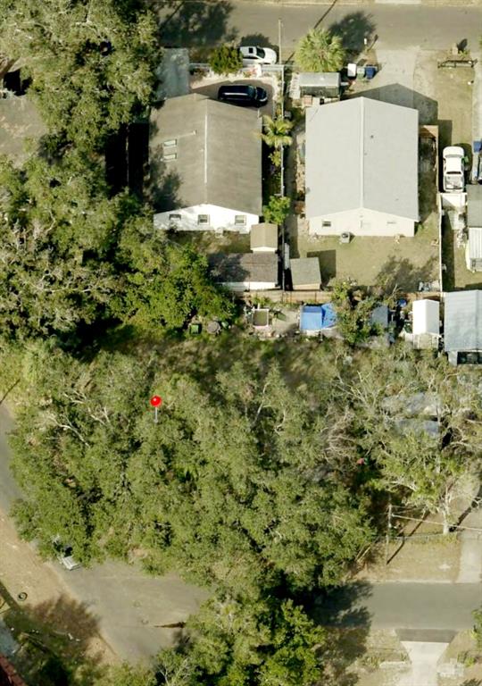 An aerial view shows a wooded lot with a red marker next to two houses — 1802 E FAIRBANKS STREET, TAMPA, FL