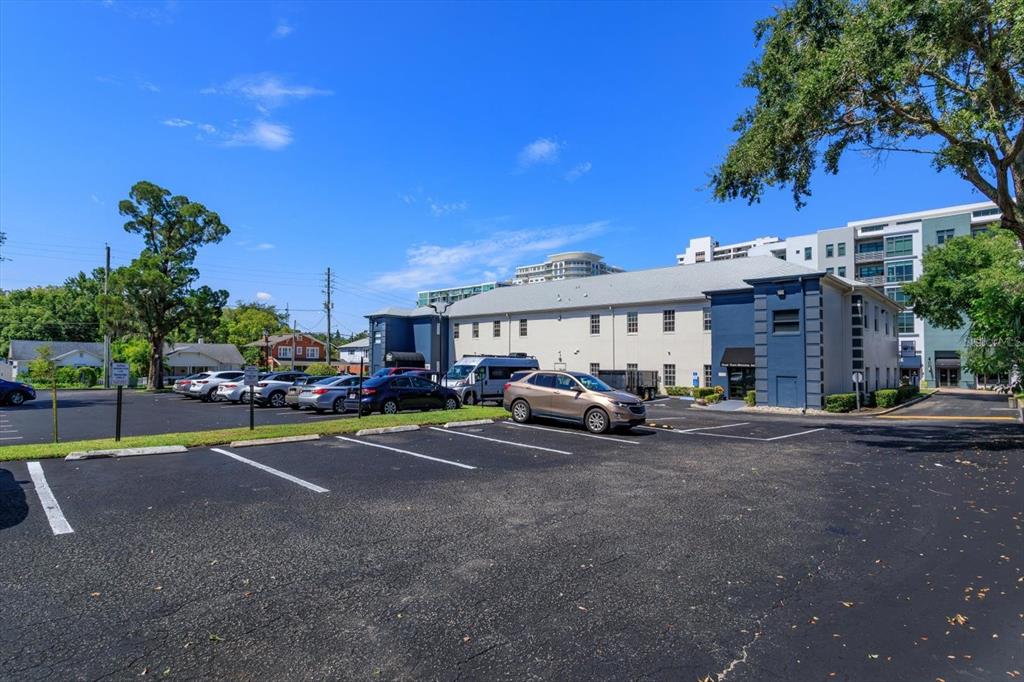 A parking lot sits in front of a two-story commercial building under a blue sky — 11 N SUMMERLIN AVENUE UNIT 100, ORLANDO, FL
