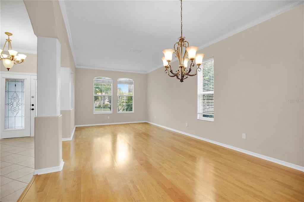 A dining room with light hardwood floors, a chandelier, and windows with white blinds — 2615 LAKEMOOR DRIVE, ORLANDO, FL