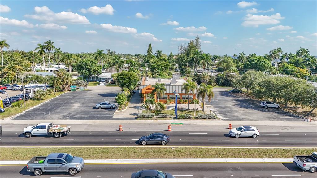 An aerial view shows a commercial building with a large parking lot along a highway — 1130 N TAMIAMI TRAIL, NORTH FORT MYERS, FL