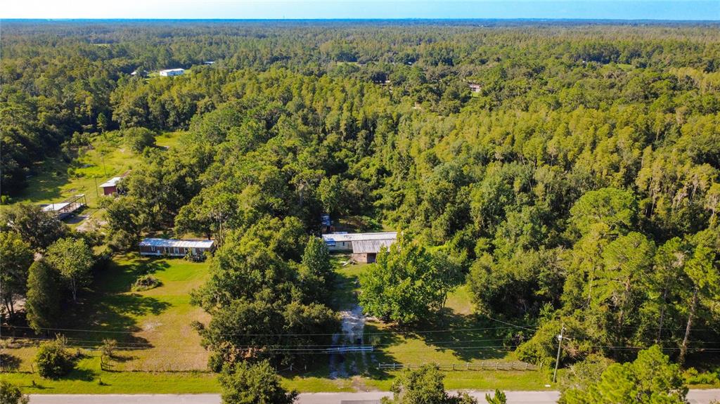 An aerial view shows a rural property with two small houses surrounded by dense forest — 326 CREEKWOOD RUN, LAKELAND, FL