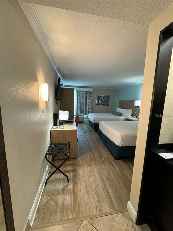 A hotel room features two beds, a desk, and wood-look flooring — 3000 MAINGATE LANE UNIT 520, KISSIMMEE, FL