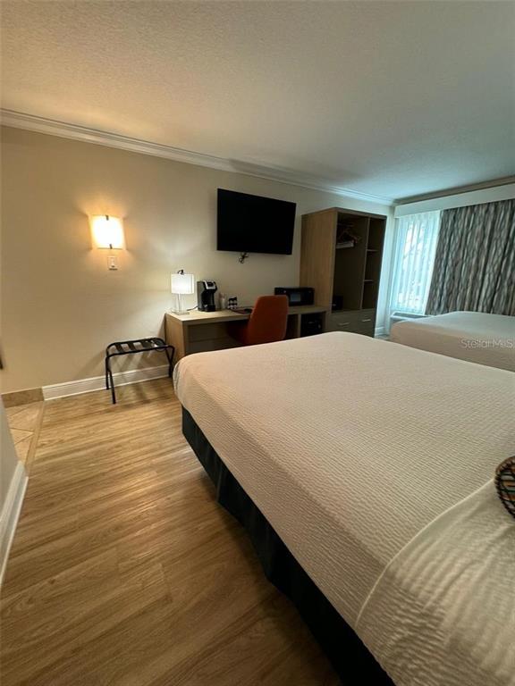 A hotel room features a bed, a desk with a chair, and a wall-mounted television — 3000 MAINGATE LANE UNIT 520, KISSIMMEE, FL