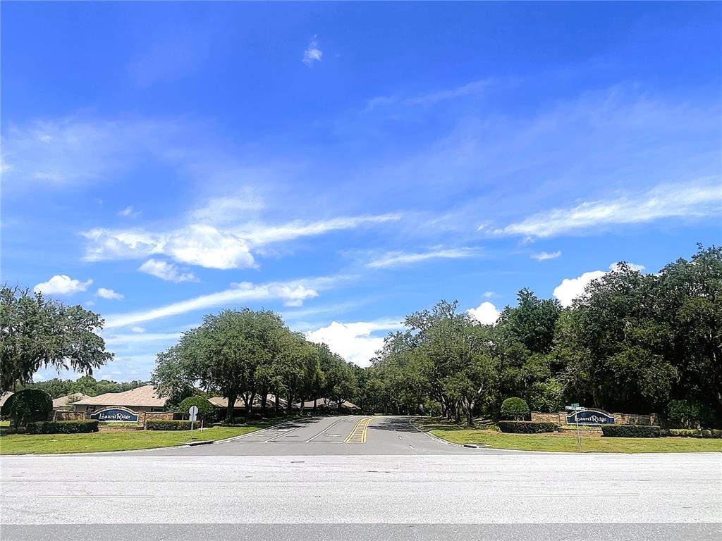 A street view shows the entrance to a Laurel Ridge community with stone signage — 521 W HILLWOOD PATH, BEVERLY HILLS, FL