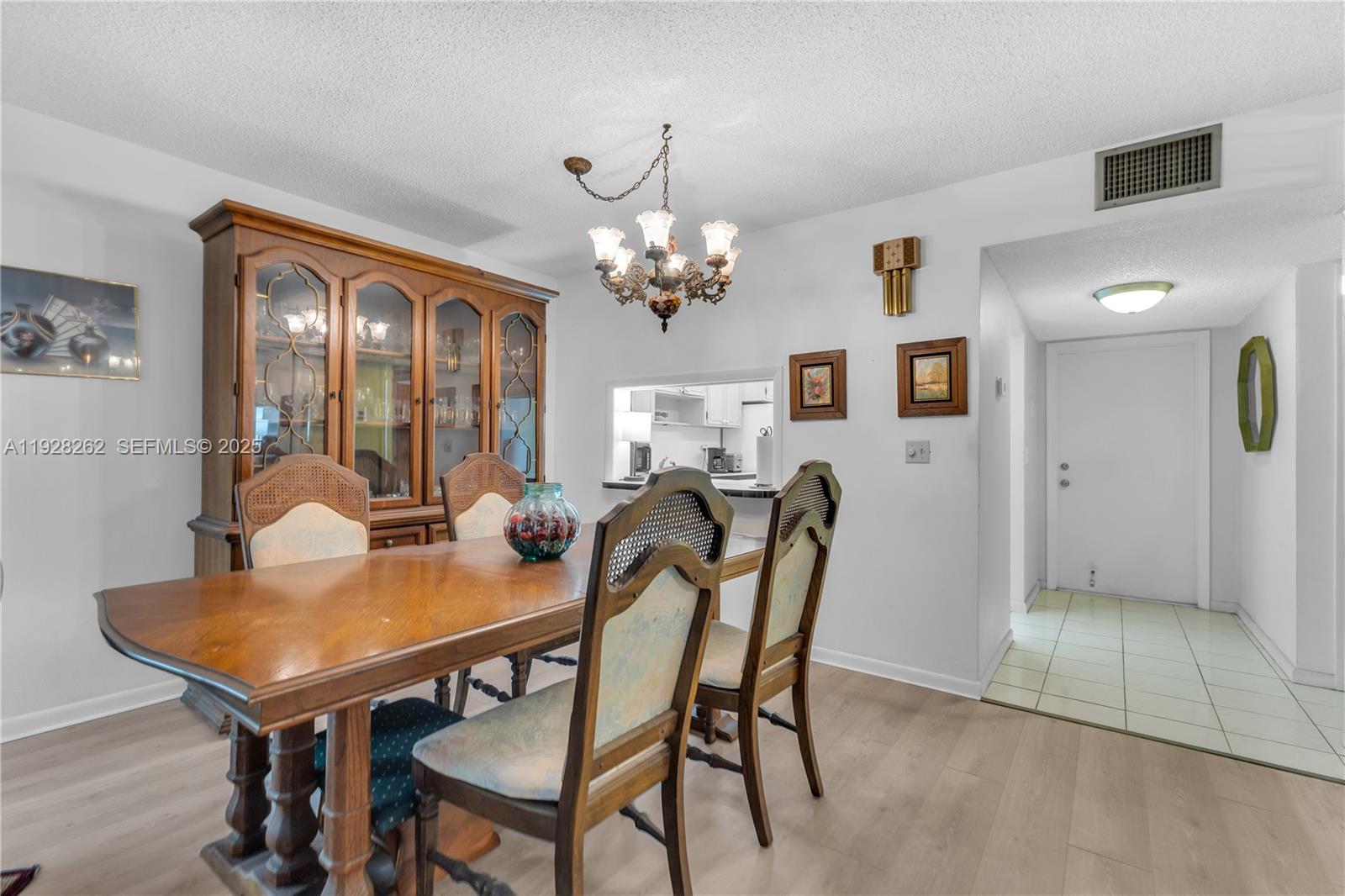 A dining room features a wooden table, chairs, a hutch, and a chandelier — 215 SE 3rd Ave # 407B, Hallandale Beach FL 33009, HALLANDALE BEACH, FL