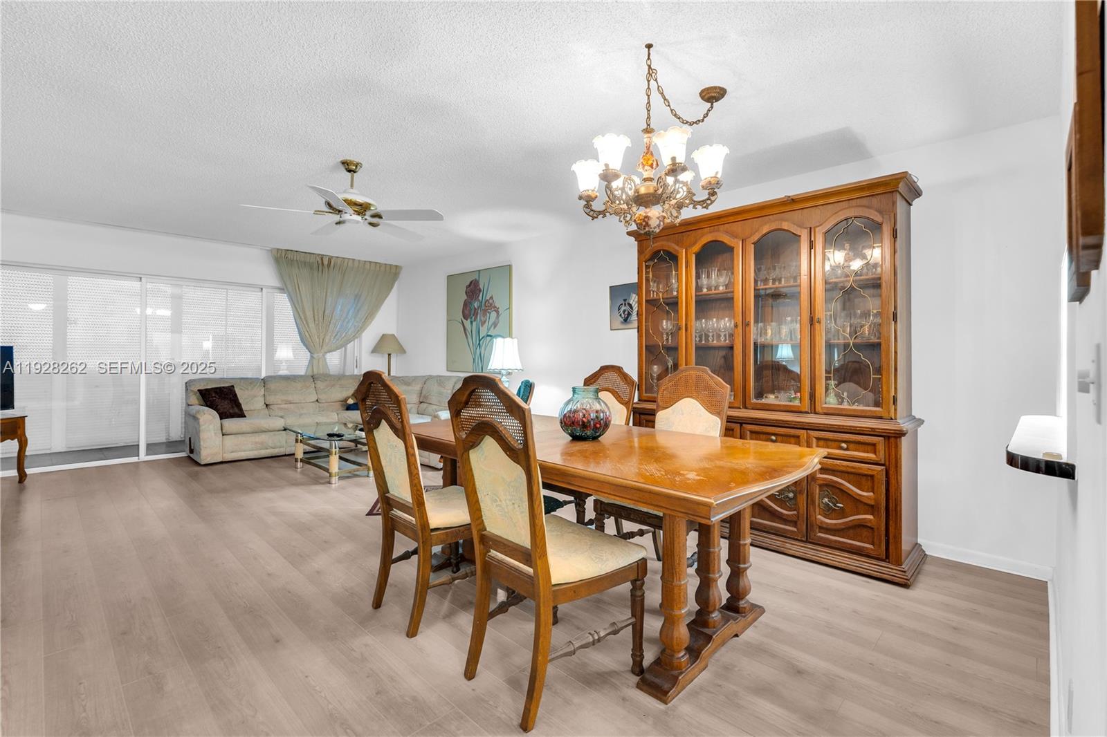 A dining area with a wooden table and hutch sits adjacent to a living room — 215 SE 3rd Ave # 407B, Hallandale Beach FL 33009, HALLANDALE BEACH, FL