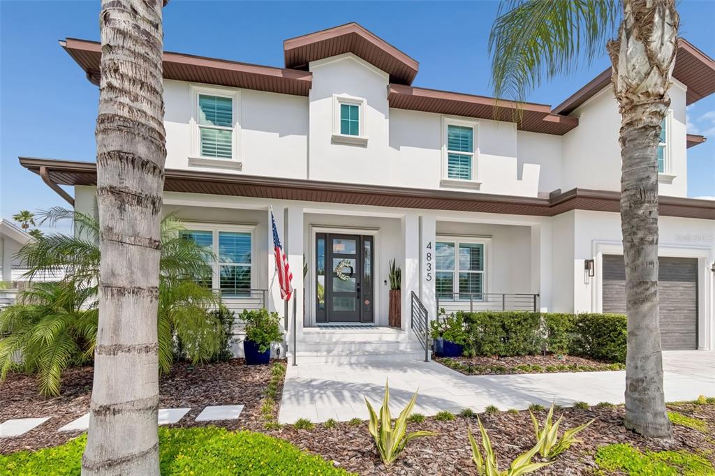 A two-story white house with a brown roof, palm trees, and a front porch — 4835 W BAY VILLA AVENUE, TAMPA, FL
