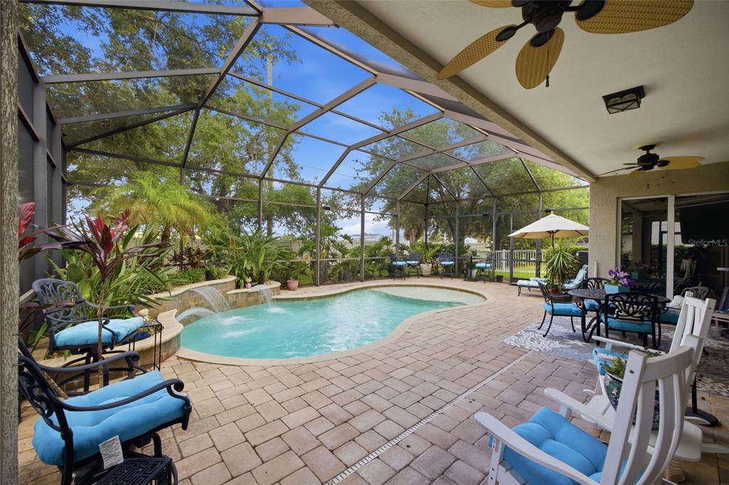 A screened-in patio features a swimming pool with water features and outdoor furniture — 4369 85TH AVENUE CIRCLE E, PARRISH, FL