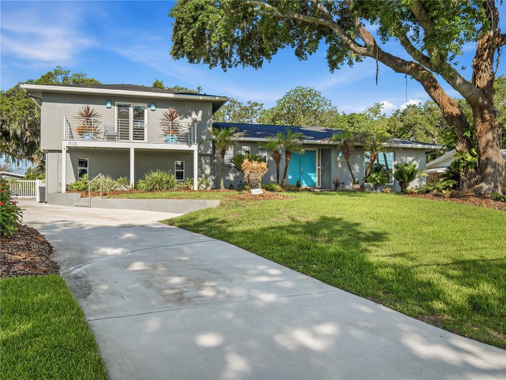 A two-story gray house with a turquoise front door and a concrete driveway — 1508 S RIVERSIDE DRIVE, NEW SMYRNA BEACH, FL