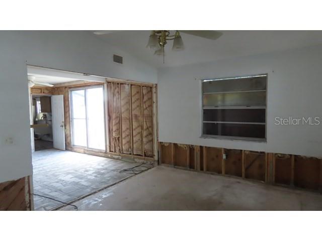 An interior room under renovation features exposed wall studs, insulation, and a sliding glass door — 6060 62ND STREET N, ST PETERSBURG, FL