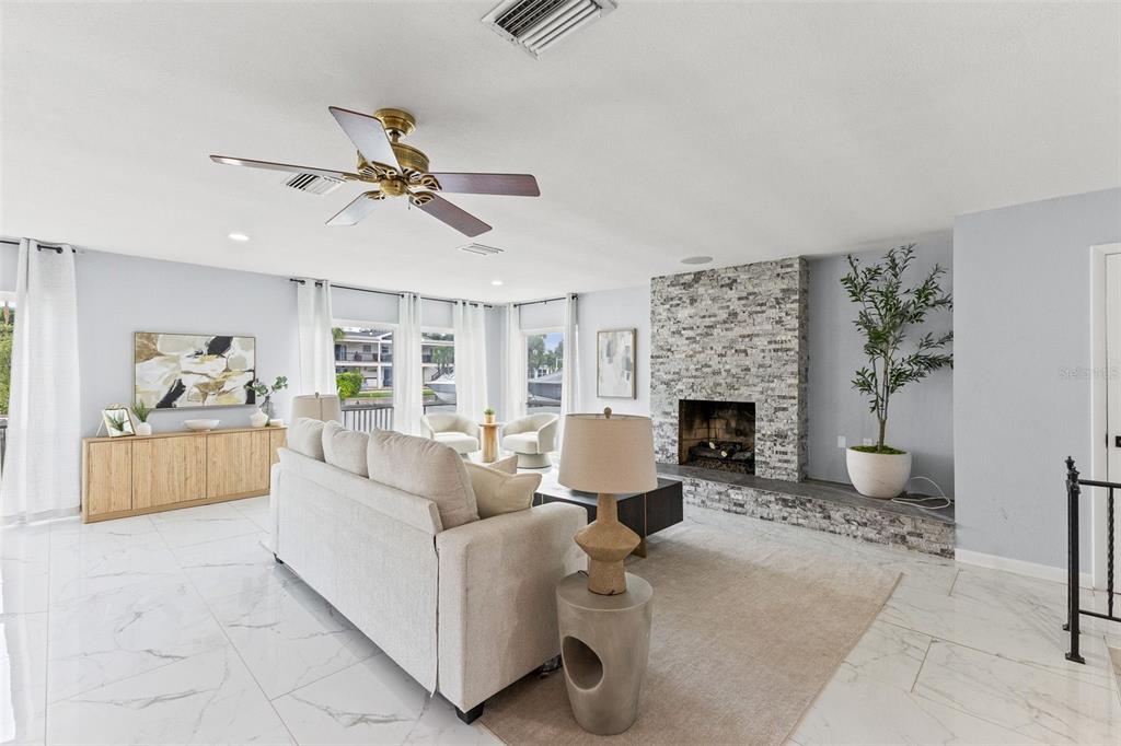 A living room features a stone fireplace, white marble floors, and a ceiling fan — 4000 14TH WAY NE, ST PETERSBURG, FL