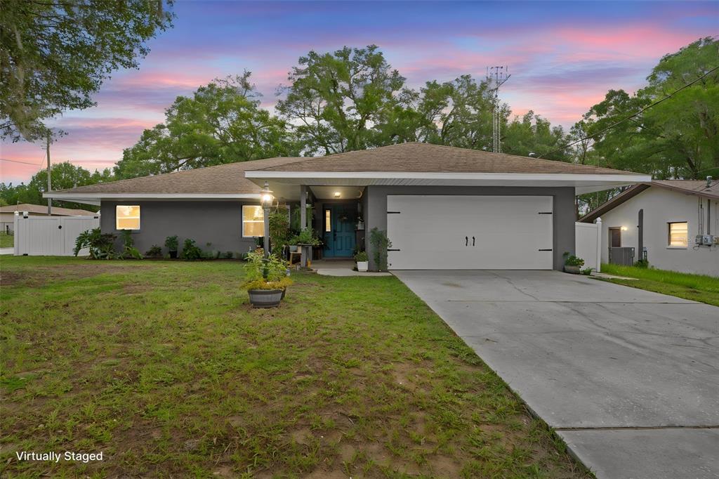 A single-story house with a gray exterior, a two-car garage, and a concrete driveway — 714 SPRUCE STREET, INVERNESS, FL