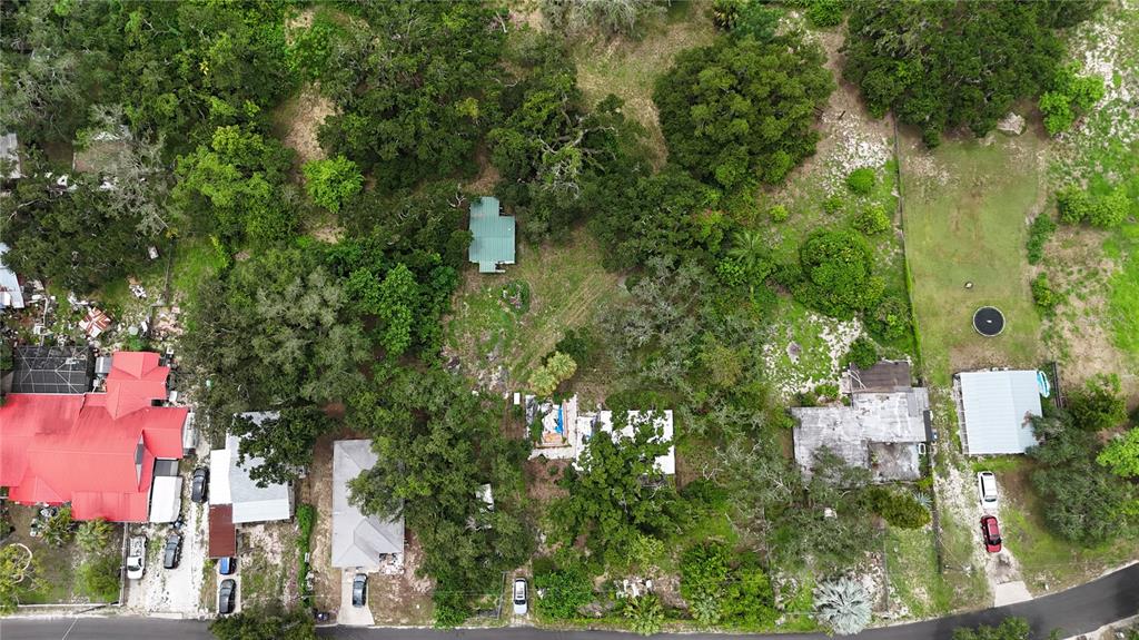 An aerial view shows several houses with various roof colors situated among many mature trees — 5404 18TH STREET BOULEVARD E, BRADENTON, FL