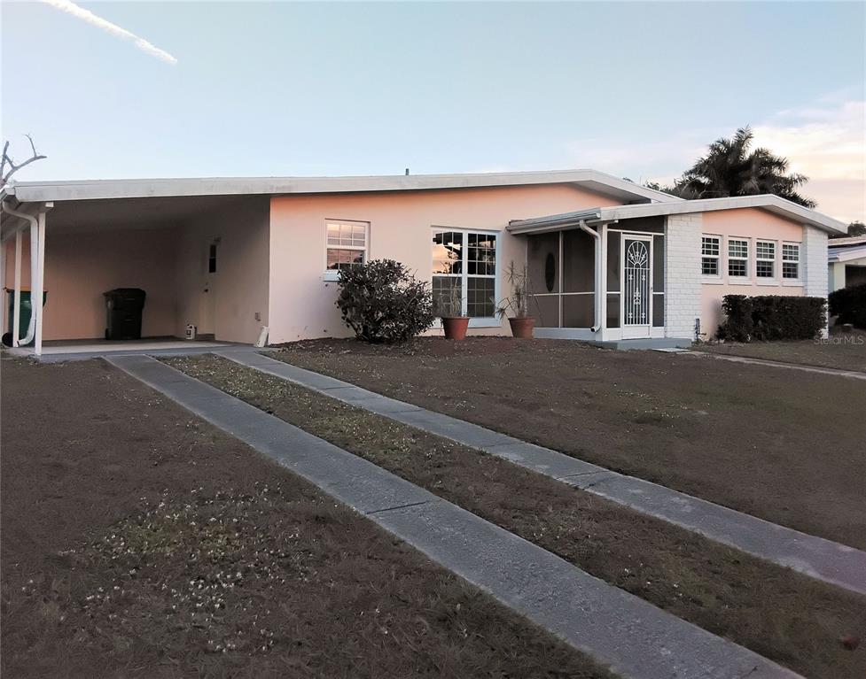 A single-story house with a carport, a screened-in porch, and a concrete ribbon driveway — 2440 ELKCAM BOULEVARD, PORT CHARLOTTE, FL