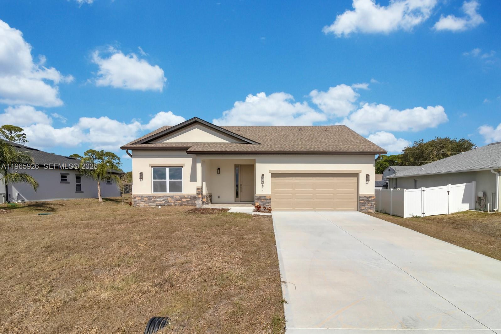 A single-story house features a tan stucco exterior, stone accents, and an attached two-car garage — 1811 MISSOURI, Palm Bay FL 32907, PALM BAY, FL