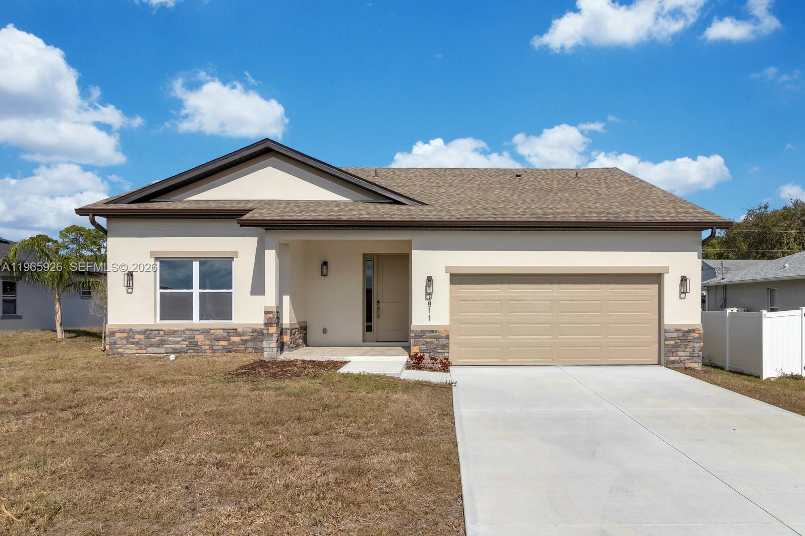 A single-story house with a beige stucco exterior, stone accents, and a two-car garage — 1811 MISSOURI, Palm Bay FL 32907, PALM BAY, FL
