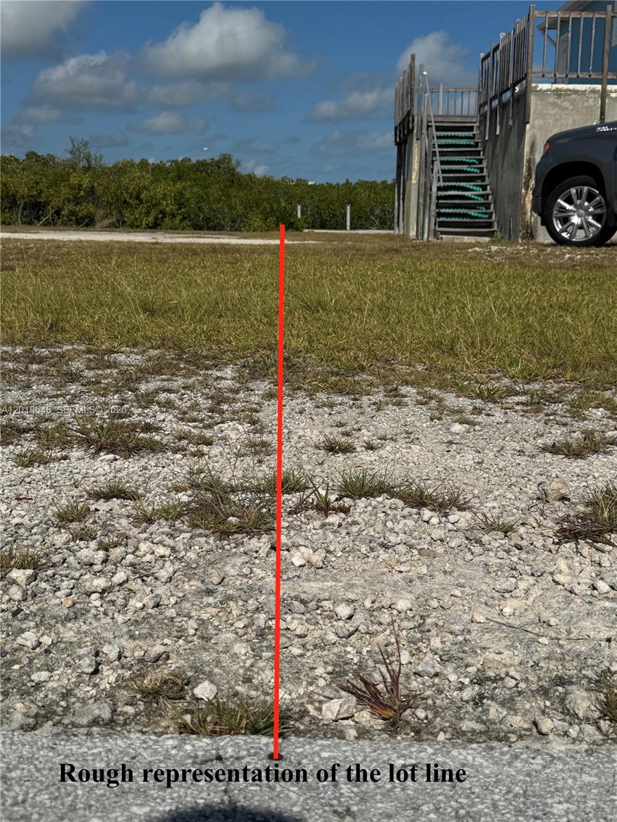 A red line indicates a property boundary on a gravel lot next to a house — Lot 27 Dorn Road, Torch Key FL 33042, TORCH KEY, FL