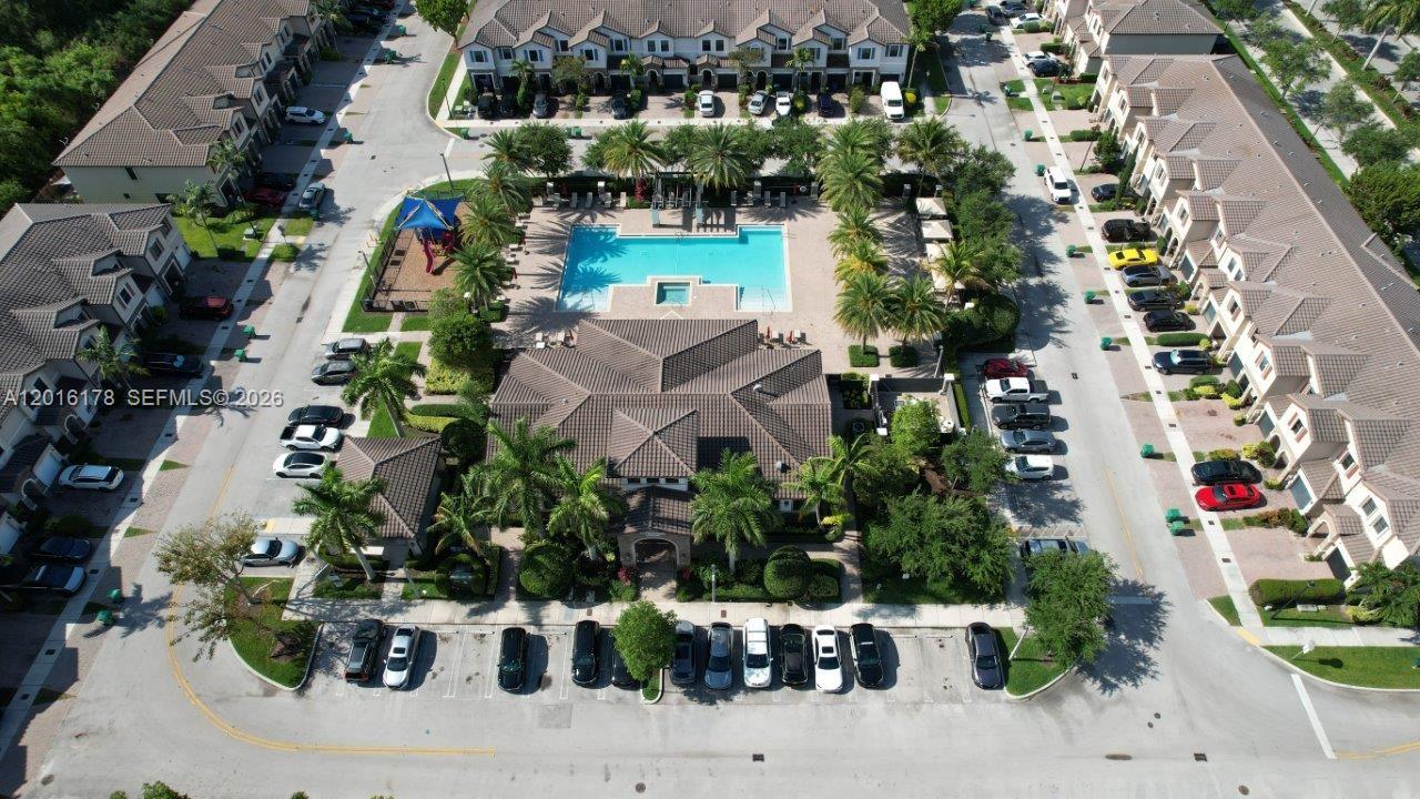 An aerial view shows a residential community with a central swimming pool and clubhouse — 11540 SW 151st Ave, Miami FL 33196, MIAMI, FL
