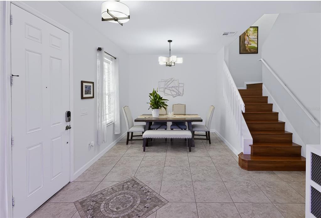 A dining area features tile floors, a wooden staircase, and a table with chairs and bench — 14613 CLARKSON DRIVE, ORLANDO, FL