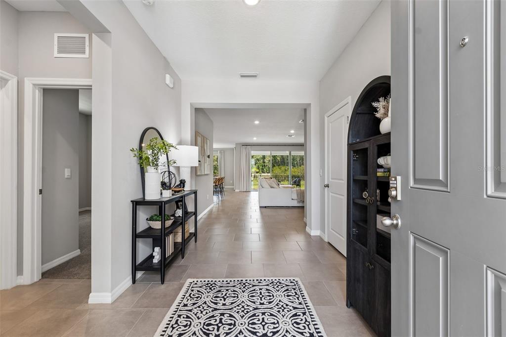 A view from an entryway into a living area with tile floors and neutral walls — 7629 BROAD RIVER AVENUE, LAND O LAKES, FL