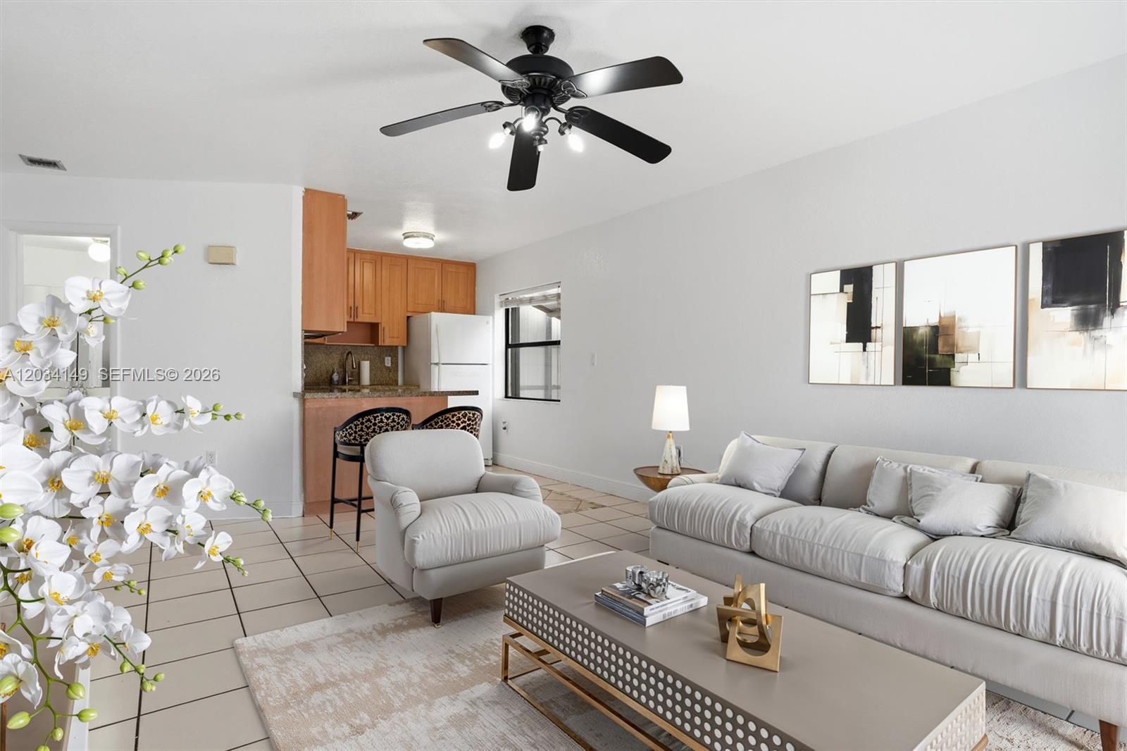 A living room with a sofa, armchair, coffee table, and an adjacent open kitchen — 1389 NW 31st Ave # B, Miami FL 33125, MIAMI, FL