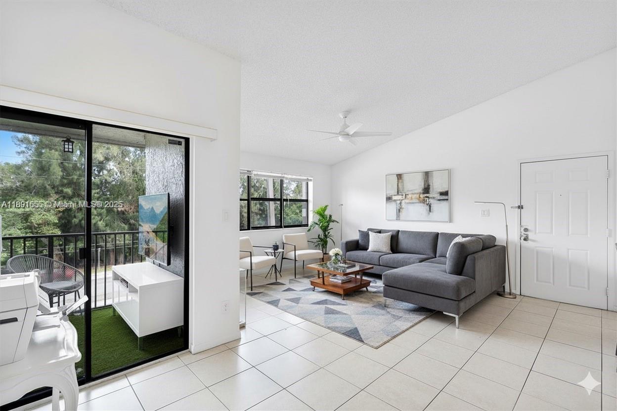 A living room features a grey sectional sofa, tiled floors, and a sliding glass door — 610 S Park Rd # 1, Hollywood FL 33021, HOLLYWOOD, FL