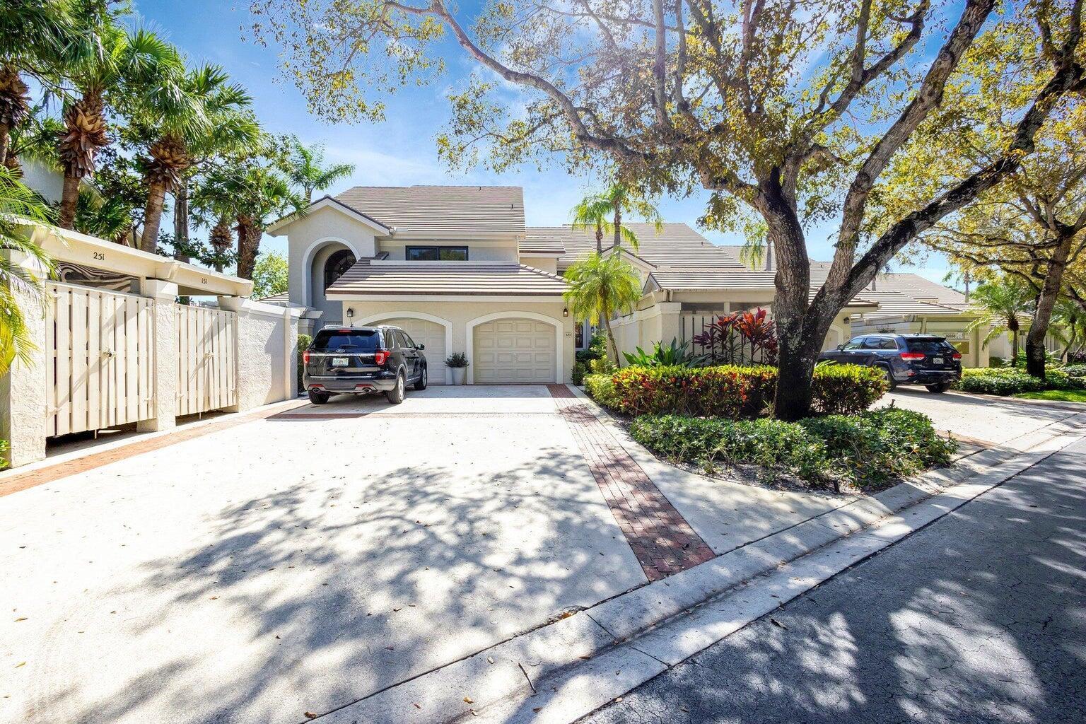 A two-story house with a two-car garage, a concrete driveway, and mature landscaping — 16050 W Bay Drive # 151, Jupiter FL 33477, JUPITER, FL
