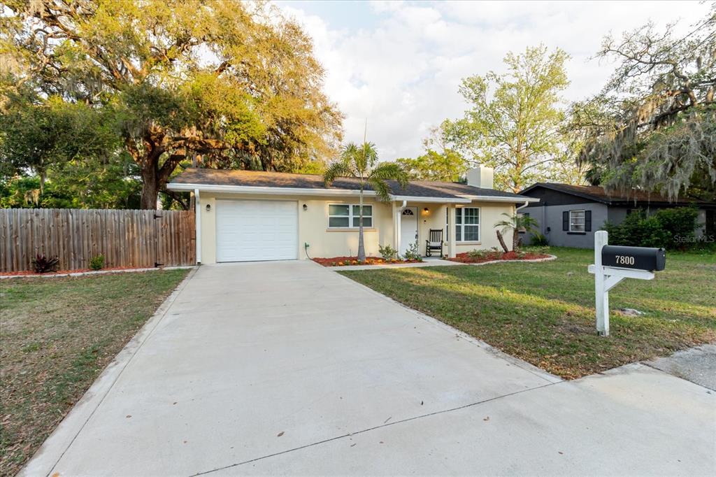 A single-story house with a white garage door, a concrete driveway, and a mailbox — 7800 WASHINGTON STREET, PORT RICHEY, FL