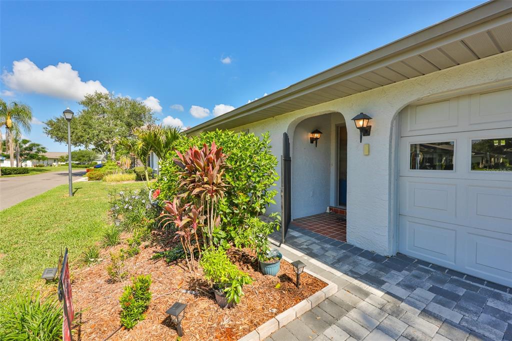A paved walkway leads to the arched entryway of a home with a garage — 1403 LANGLEY DRIVE, SUN CITY CENTER, FL