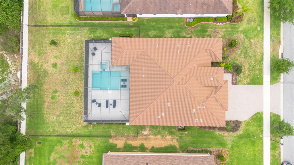 An aerial view shows a house with a tiled roof, a screened pool, and a yard — 113 BROOKOVER LANE, BRANDON, FL